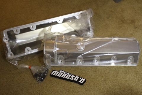 2003 Ford Crown Victoria - Two welded aluminum valve covers in plastic wrap beside a small bag of mounting hardware and a black Moroso badge.