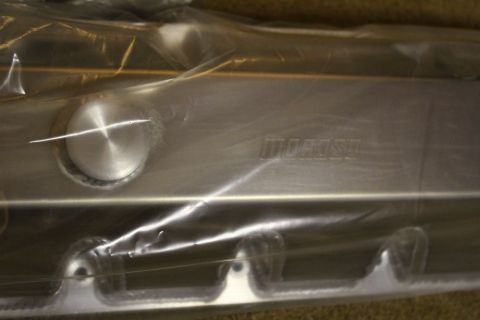 2003 Ford Crown Victoria - Close-up of a plastic-wrapped fabricated aluminum valve cover, showing a round filler cap and a faint Moroso stamp.