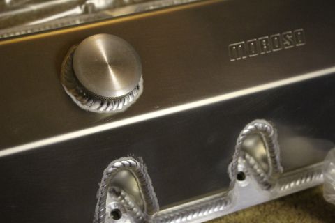 2003 Ford Crown Victoria - Close-up of a brushed aluminum valve cover showing the filler cap, the Moroso stamp, and rope-welded bolt bosses below.