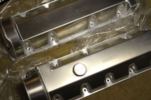 2003 Ford Crown Victoria - Two fabricated aluminum valve covers with rope-welded bolt bosses, both bearing Moroso stamps, laid on carpet.