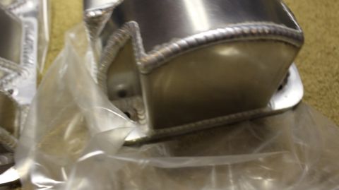 2003 Ford Crown Victoria - Close-up of the welded end of a fabricated aluminum part, showing a decorative rope-style weld bead through plastic wrap.