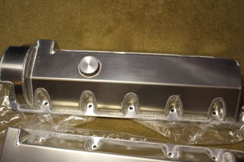 2003 Ford Crown Victoria - single fabricated aluminum valve cover with a filler cap and rope-welded bolt bosses, laid in plastic wrap on carpet.