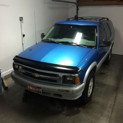 1995 Chevrolet Blazer - This blue 1995 Chevrolet Blazer is parked inside a garage with the door partially open.