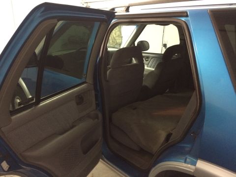 1995 Chevrolet Blazer - The interior of a blue SUV is visible, with the rear seats folded down.