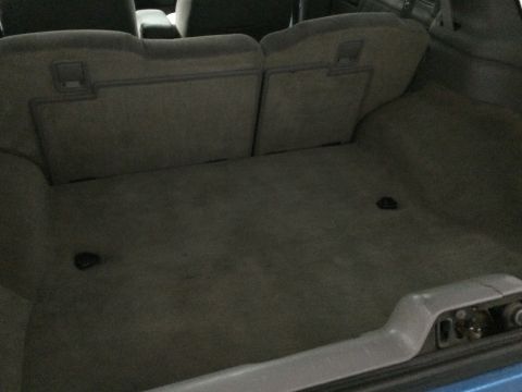 1995 Chevrolet Blazer - The cargo area of the vehicle is shown with the rear seats folded down, revealing the carpeted floor and side panels.