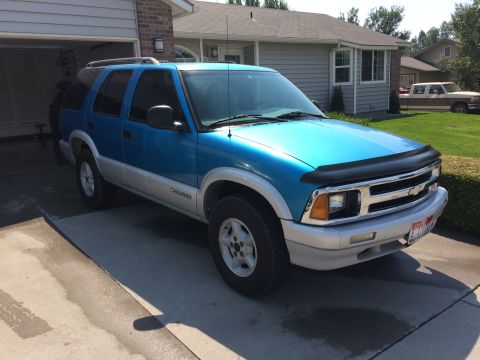 1995 Chevrolet Blazer - This Chevrolet Blazer is parked in front of a residential garage. A second vehicle is visible in the background.