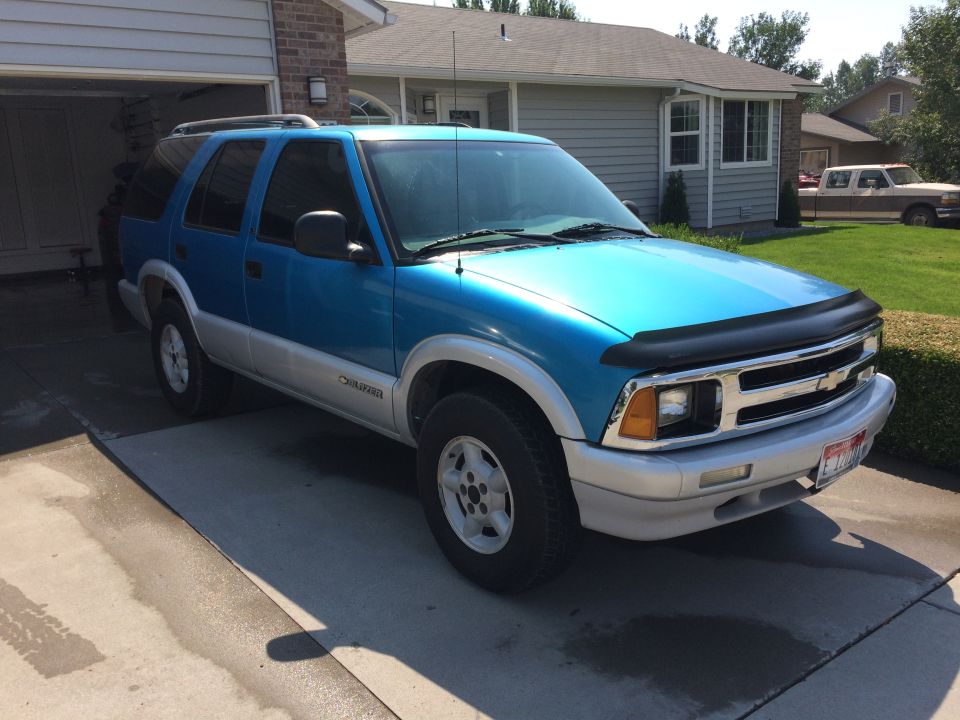 Blue two-tone Chevrolet Blazer parked in a driveway. It has a bug deflector on the hood