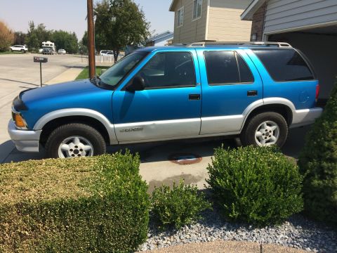 1995 Chevrolet Blazer - Side view of a blue 1995 Chevrolet Blazer SUV parked in a residential driveway.