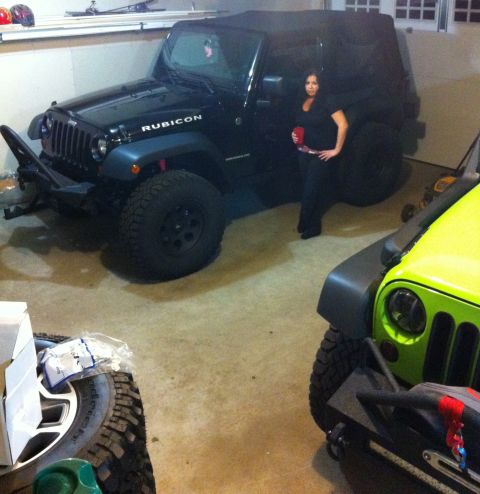 2013 Jeep Wrangler - A black Jeep Wrangler is parked in a garage next to a lime green Jeep.