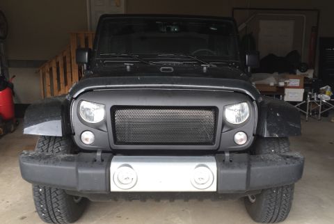 2013 Jeep Wrangler - Black Jeep Wrangler with custom grille and bumper, parked indoors. Supermotors.net logo is present.