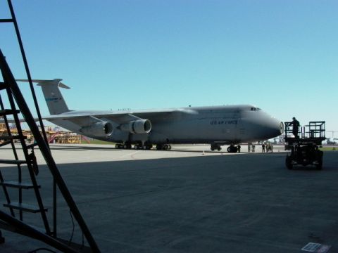 1990 Ford Bronco - A large US Air Force cargo plane is seen on the tarmac under a clear blue sky.
