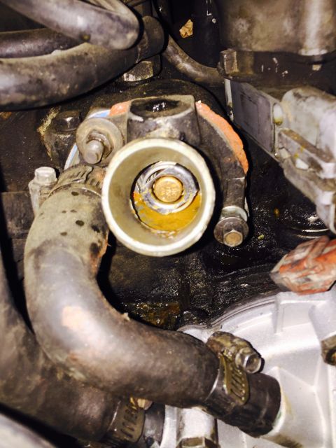 1988 Ford Bronco - Close-up of a vehicle's engine compartment, focusing on the thermostat housing and associated hoses.