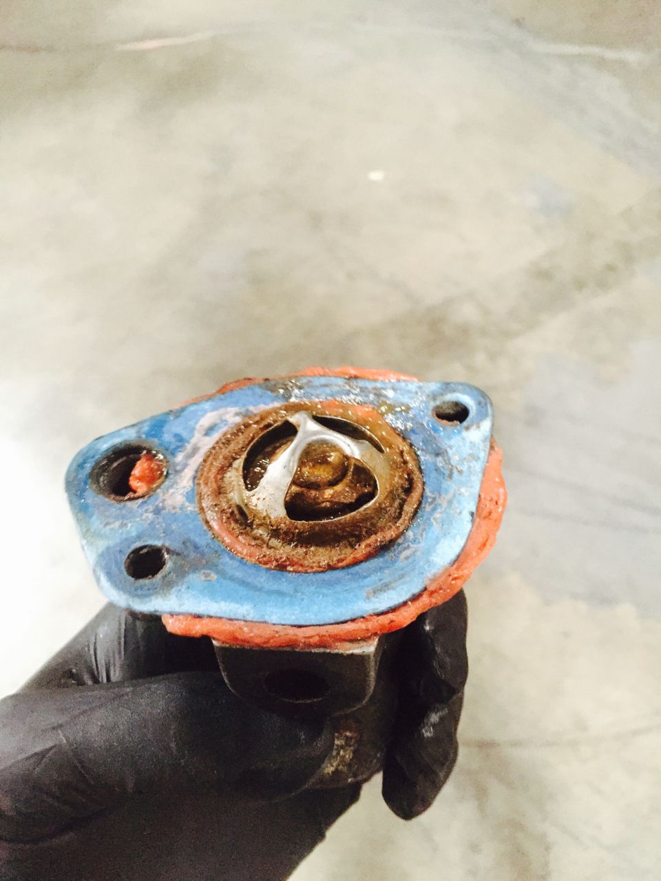 Thermostat housing with orange gasket and corroded metal element