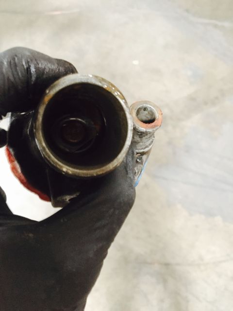 1988 Ford Bronco - Close-up of a used metal part held in a gloved hand.