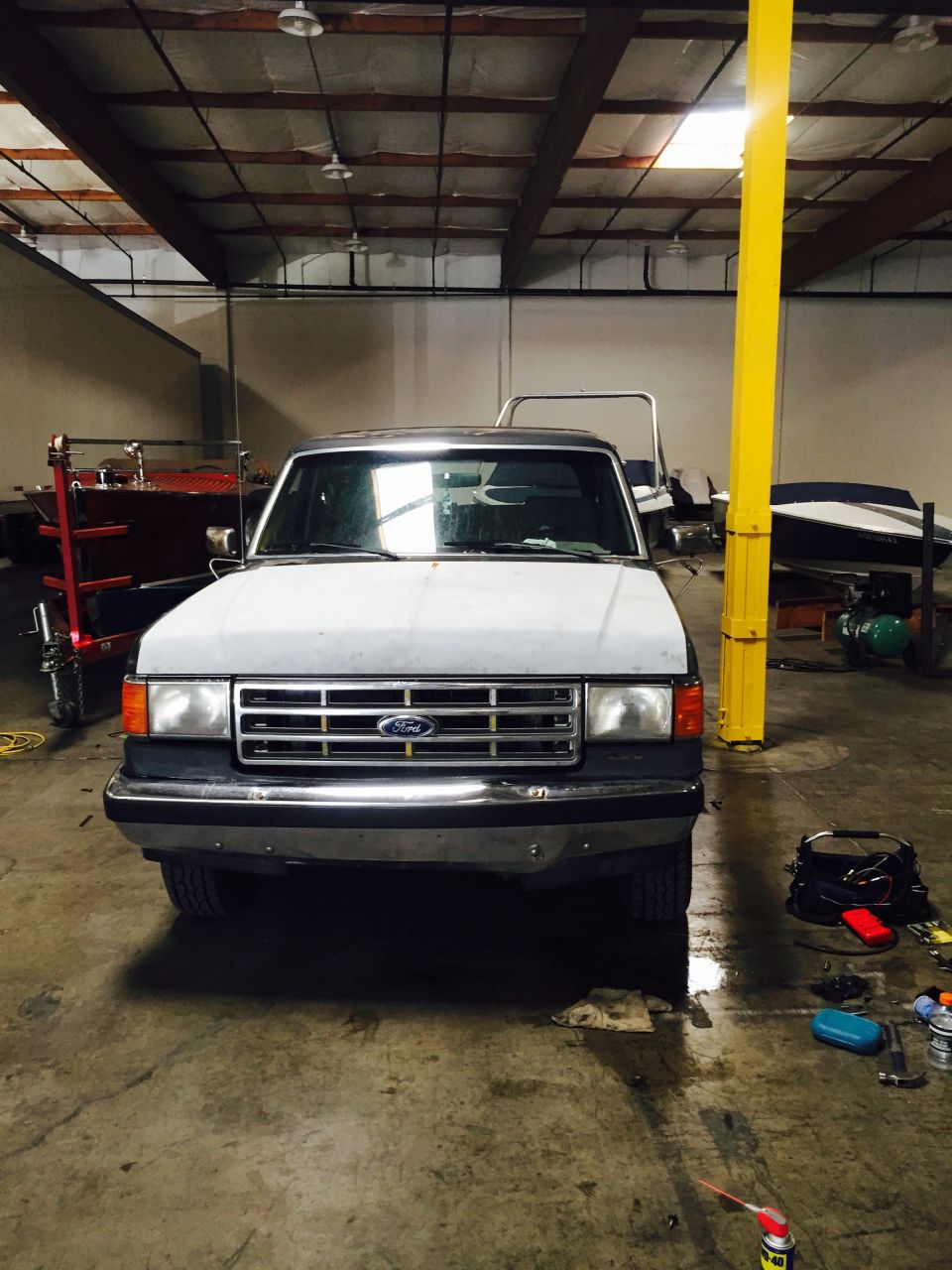 White Ford Bronco with a chrome grille and bumper, parked indoors