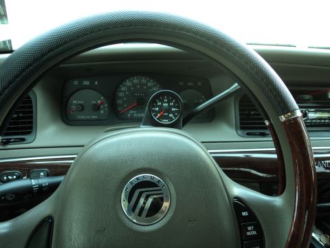 2004 Mercury Grand Marquis - The dashboard of a 2004 Mercury Grand Marquis shows the speedometer, tachometer, and a mounted aftermarket tachometer.