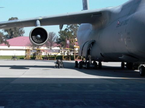 1990 Ford Bronco - A C-5 Galaxy aircraft is parked on the tarmac, with a person in a wheelchair nearby.