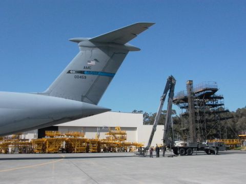 1990 Ford Bronco - Tail section of a C-5 Galaxy military cargo plane at an airfield with ground support equipment.