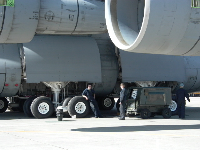 people near large aircraft landing gear and engines