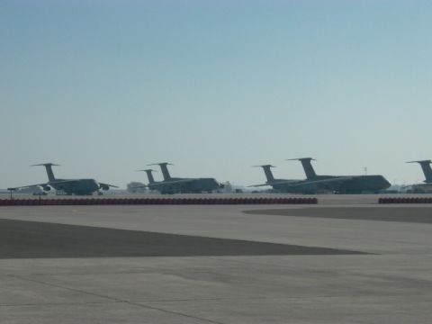 1990 Ford Bronco - Multiple cargo airplanes are parked on an airfield on a clear day.