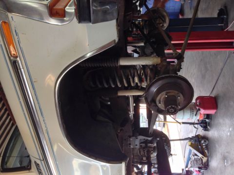 1979 Ford Bronco - Front suspension and wheel assembly of a 1979 Ford Bronco, likely undergoing maintenance or repair.