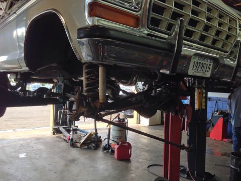 1979 Ford Bronco - Undercarriage view of a 1979 Ford Bronco undergoing service on a lift.