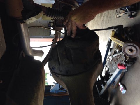 1979 Ford Bronco - A mechanic works on a vehicle's rear axle assembly, with "Supermotors.net" visible in the lower right corner.
