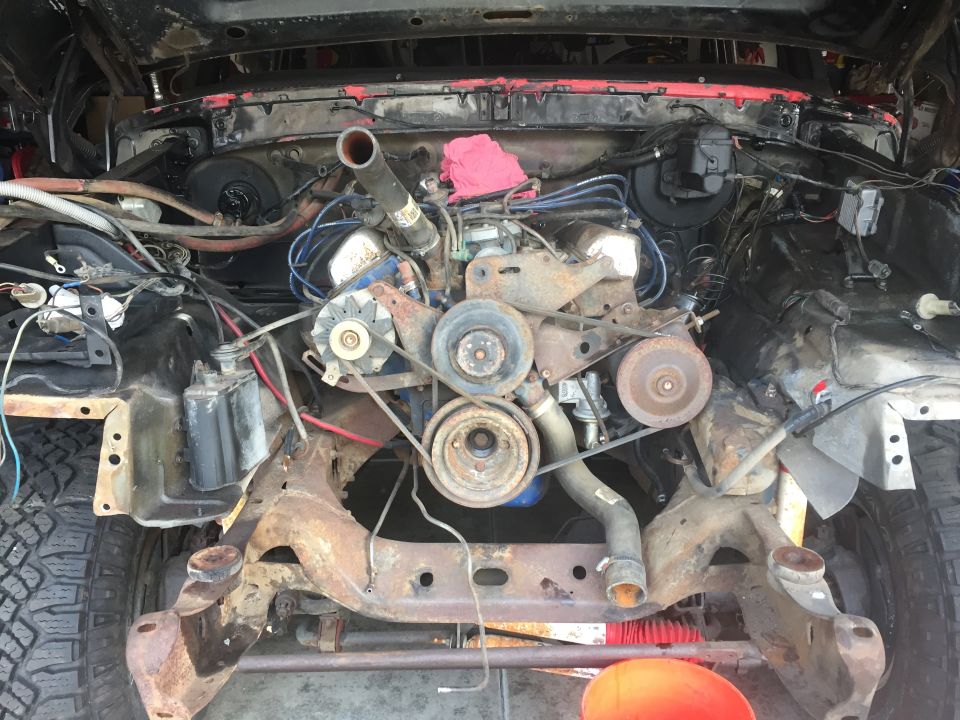Engine bay with V8 engine, rusty chassis components
