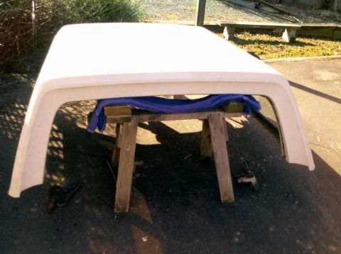 1982 Ford Bronco - Truck cap supported by sawhorses, ready for work or storage.