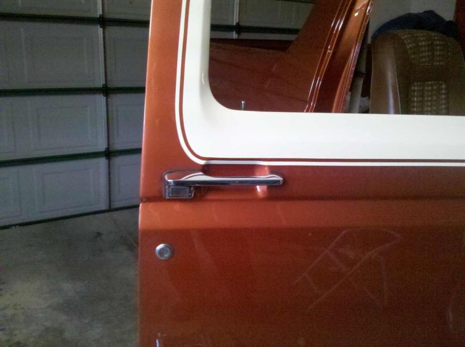 Orange 1982 Ford Bronco door with white trim and chrome handle
