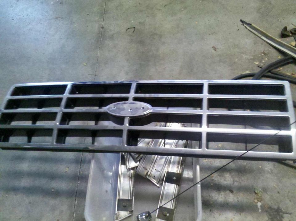Ford oval emblem on a chrome grille, possibly from an 80s truck