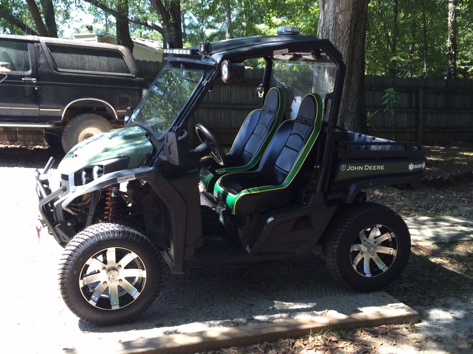 John Deere Gator UTV, side view, black and green seats, aftermarket wheels