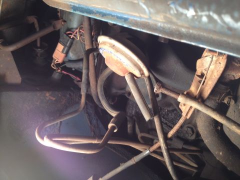 1973 Ford Bronco - Close-up view of engine bay components, including a distributor cap and spark plug wires.