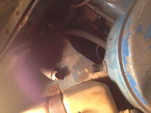 1973 Ford Bronco - Close-up view of engine bay components, showing hoses and metal parts with signs of wear and rust.