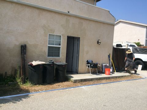 1968 Ford Mustang - A white pickup truck is parked next to a house with trash bins and a person walking.