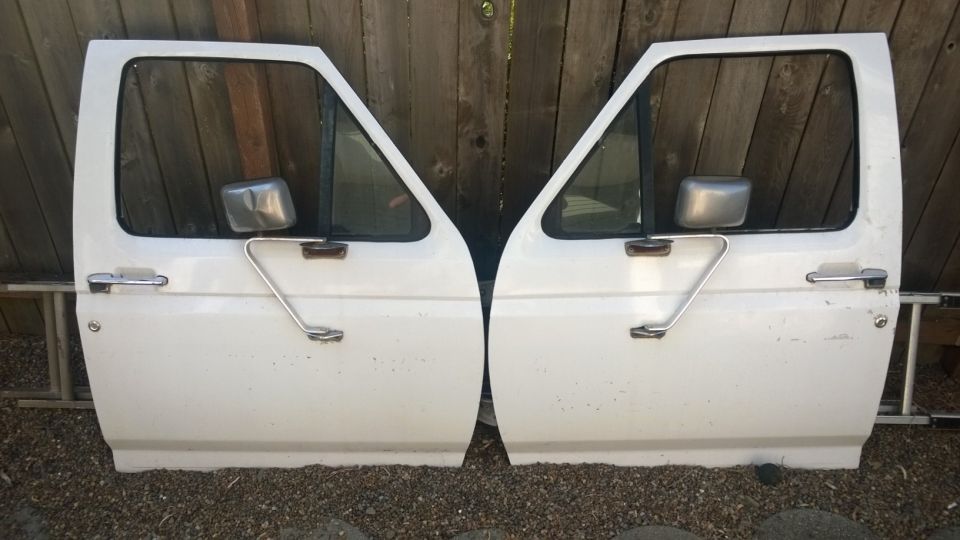 Two white truck doors with side mirrors and door handles