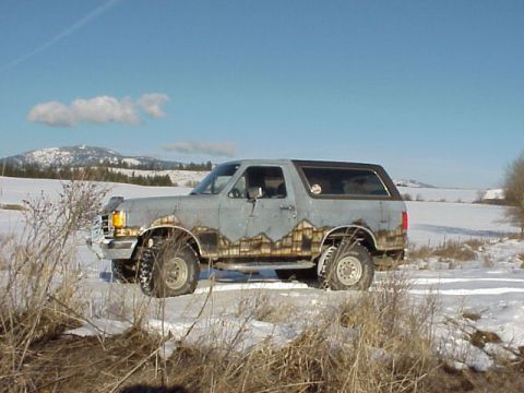 1989 Ford Bronco - This 1989 Ford Bronco is seen in a snowy landscape with custom paintwork along its lower body.