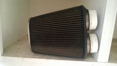 1994 Ford Bronco - A used air filter with two white adapters sits on a shelf.