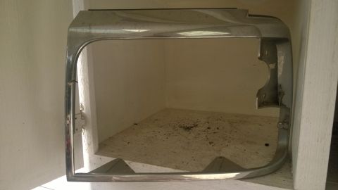 1994 Ford Bronco - Headlight bezel for a 1994 Ford Bronco, showing chrome trim and mounting points.