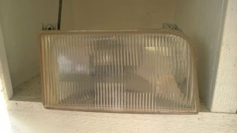 1994 Ford Bronco - A single headlight assembly is shown, resting on a shelf.