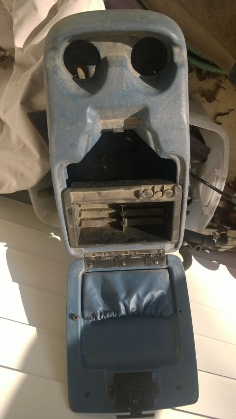 1994 Ford Bronco - This is a blue plastic center console with an open storage compartment and two circular openings on top.