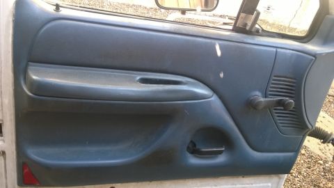 1994 Ford Bronco - Close-up of a vehicle's interior door panel, showing the window crank and handle mechanism.