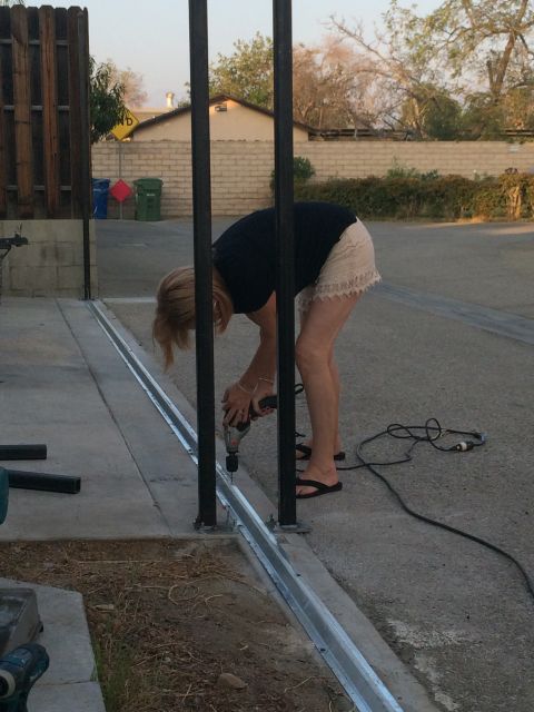 1968 Ford Mustang - Woman installing a metal track on a concrete surface outdoors.