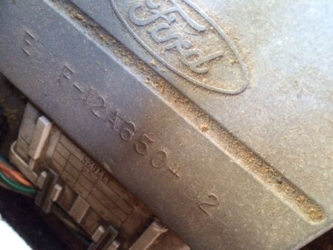 1983 Ford Bronco - A close-up view of a Ford part with a serial number and attached wiring harness.
