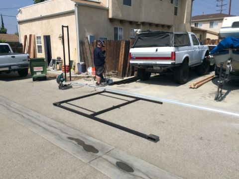 1968 Ford Mustang - A white pickup truck with a black camper shell is parked in a driveway next to a boat and construction materials.