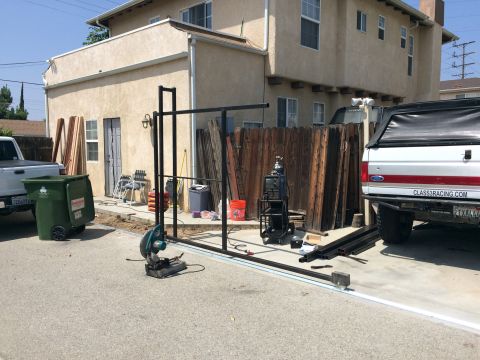 1968 Ford Mustang - A white 1987 Ford F-Series pickup truck is parked next to a wooden fence, with construction materials and equipment nearby.