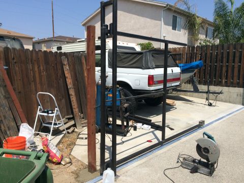1968 Ford Mustang - A white Ford pickup truck is parked next to a fence, with a boat trailer attached. Construction equipment is visible in the yard.