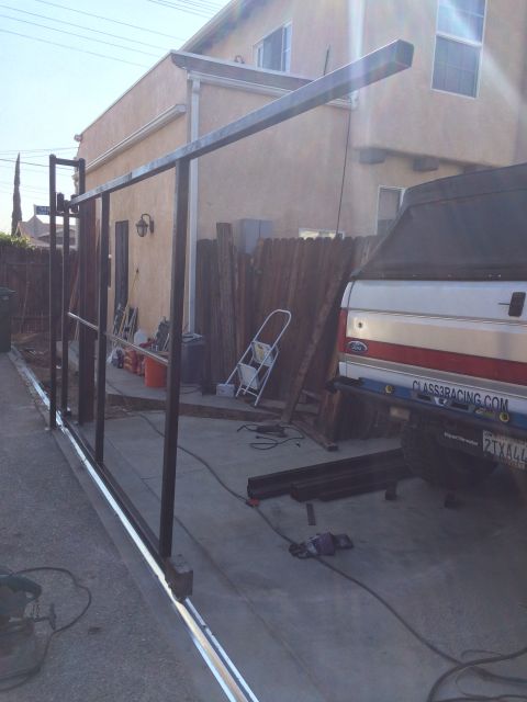 1968 Ford Mustang - A white and red Ford Bronco is parked next to a metal gate construction project.