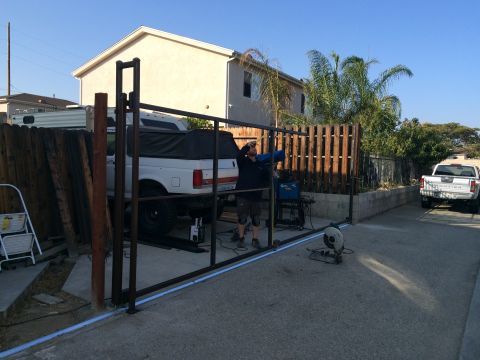 1968 Ford Mustang - A white pickup truck is parked in a driveway while a metal gate is being constructed.