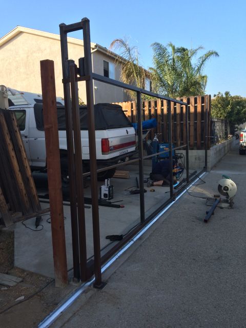 1968 Ford Mustang - A white pickup truck is parked in a driveway while a metal gate is being constructed.